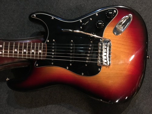 Black and chrome Tokai TSS-38 guitar with gold hardware, silver pickguard, and dark wood fretboard on carpet background.