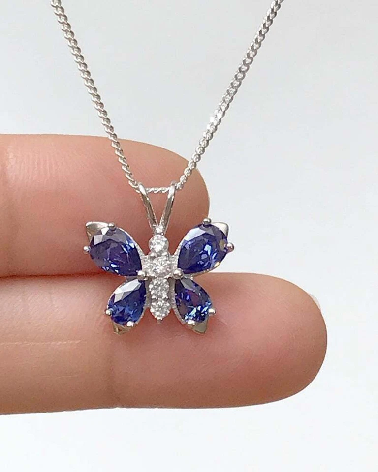 Colgante mariposa de diamantes y tanzanita azul simulado de 1,5 quilates acabado en oro blanco de 14 quilates Foto 2 de 4
