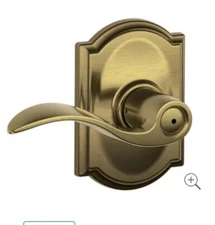 Schlage Accent Lever with Camelot Trim Bed and Bath Lock in Antique Brass - F40