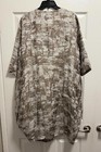 Chalet et Ceci green linen long sleeve dress with back tie waist, displayed on black hanger against white door.