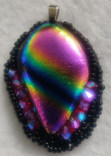 Multi colored dichroic glass pendant surrounded by Swarovski crystals