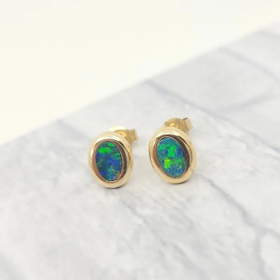 Aretes simples ovalados naturales de ópalo doblete australiano de oro amarillo de 14 k Foto 2 de 4