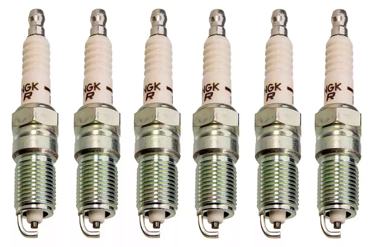 A set of six of copper-core NGK spark plugs, displayed on a white surface.