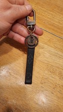 Louis Vuitton Porte-Cles Dragonne Key Holder monogrammed strap metal hardware.