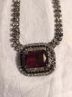 vintage-style rhinestone necklace with a large, rectangular red faux ruby or...