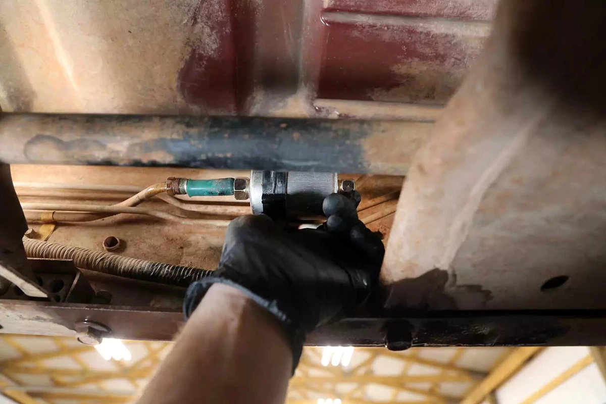 A mechanic slides the new fuel filter into its plastic ring mount.