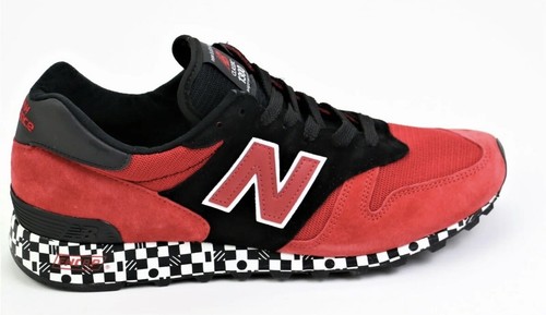 Red and black New Balance 1300AP sneaker with white “N” logo, suede panels, and black checkered base sole.