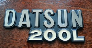 Insignia coche Datsun 200l emblema plástico parece nunca usada como nueva