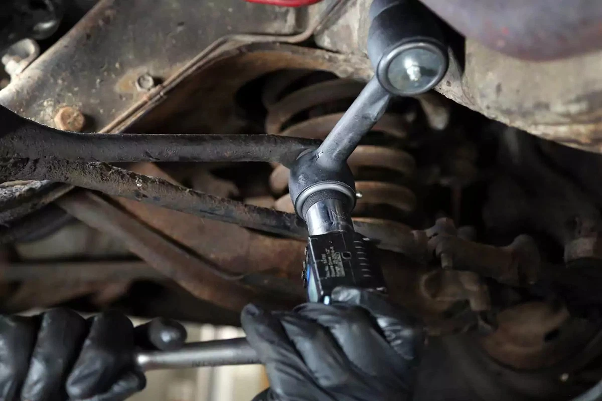 Using a torque gauge to tighten the castle nuts on an idler arm.