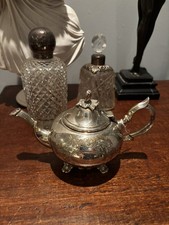 Antique silver-plated teapot with ornate, hand-chased floral and scroll patterns
