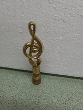polished brass music note lamp finial, specifically designed in the shape of...