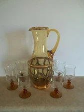 Amber color pitcher heavily encrusted with gold and 6 amber goblets