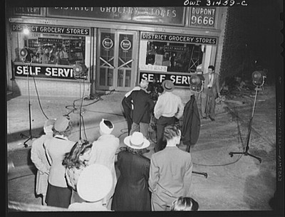 People gathered in front of a District grocery store where some men with