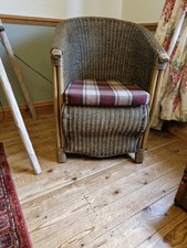 A Vintage Wicker Tub Style Chair And Checked Seat Cushion