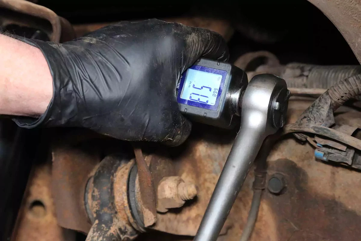 Torquing the shock absorber bolt with a ratchet and torque box.