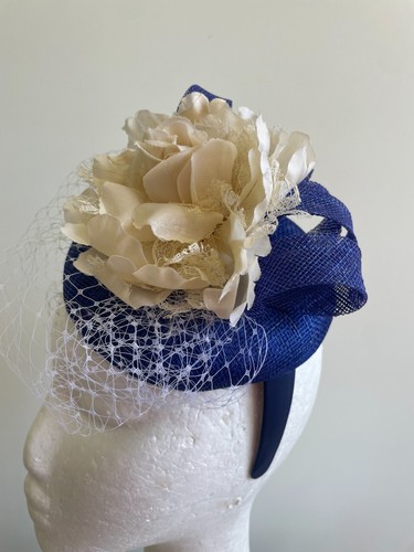 Blue button base fascinator with blue sinamay loops, cream flower and netting - Picture 2 of 5