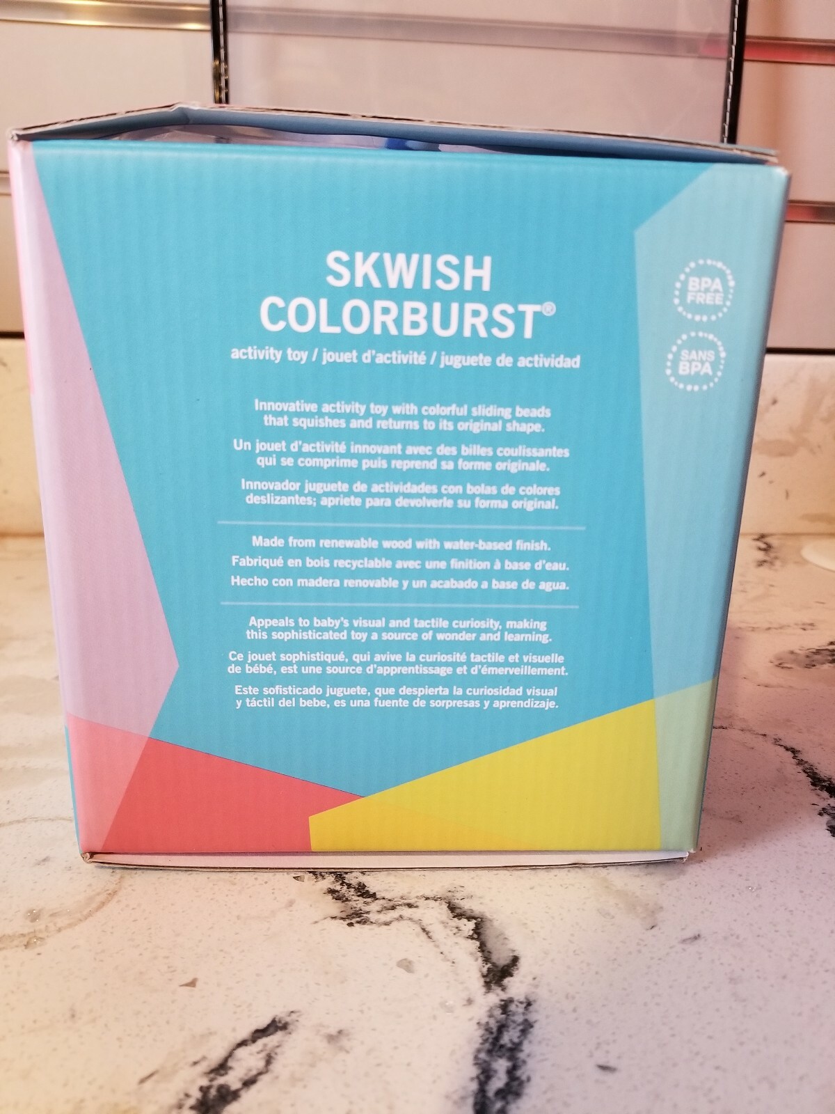 manhattan toy skwish color burst rattle and teether grasping activity toy