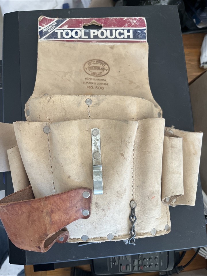 A vintage Nicholas leather 10-pocket tool pouch still with its original cardboard packaging — pristine old-stock workwear artifact that's both beautiful and usable.