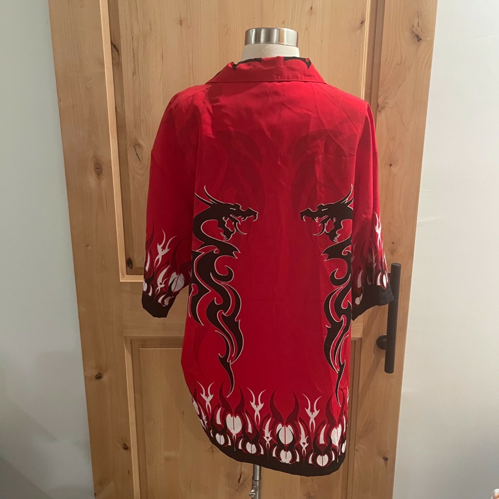 A fiery red dragon with large wings flies through a stormy sky with