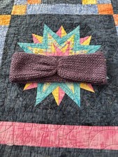 A knitted adult headband, lilac purple, made with acrylic, wool, and nylon yarn