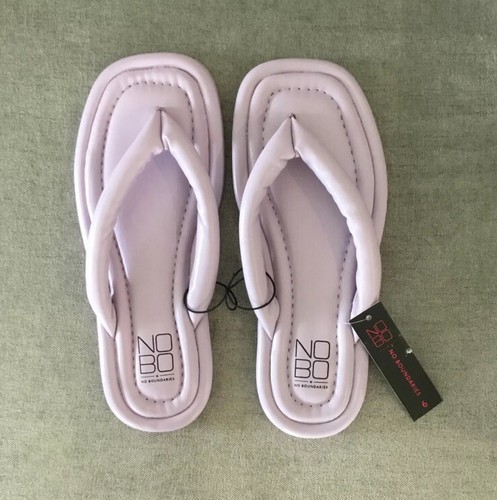 Vertical Image of a Pair of Vibrant Pink and Purple Flip-flops Sandals on the Sandy Beach Stock