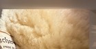 Close-up of tan suede bucket hat with visible seams and textured brown sheepskin lining, made in USA.