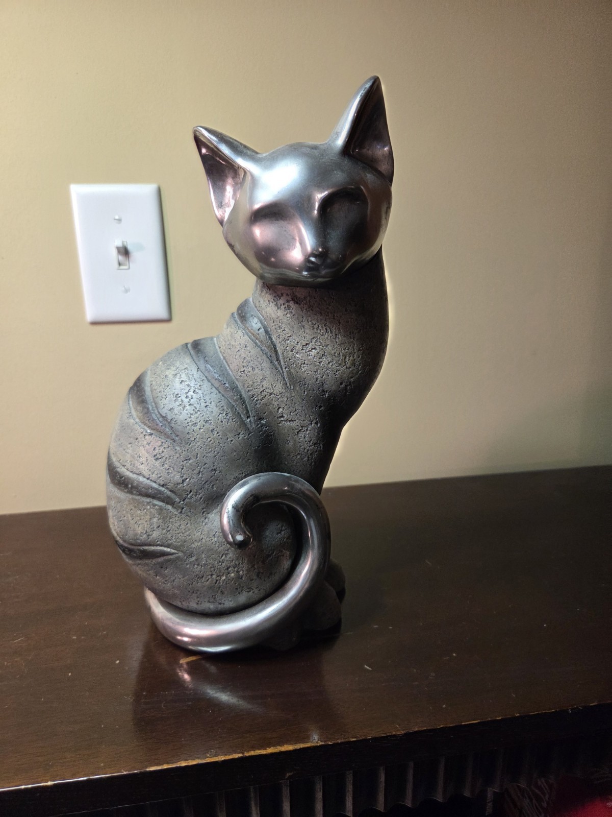 Cat Sculpture With A Chrome Head And Tail Body Is A Gray W/ Black Strips.