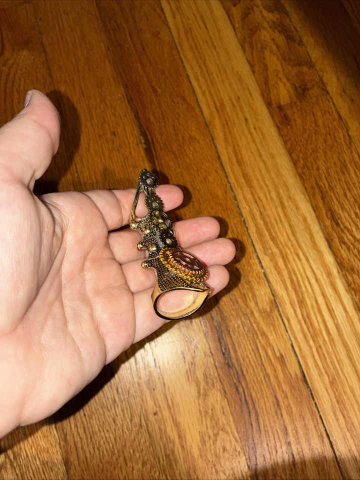 A fully articulated, gear-adorned finger armor ring that moves with your hand — wearable steampunk sculpture.