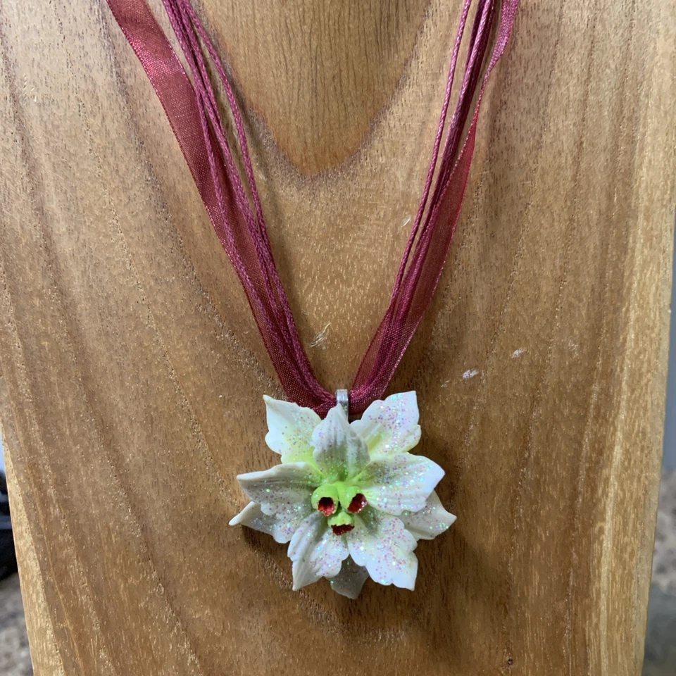 Collar/garra de cerámica blanca con brotes verdes y brillo en una cinta granate Foto 2 de 4