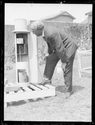 Mr Mares from the Weather Bureau reading an outside thermometer, N - Old Photo