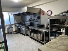 Une cuisine de restaurant entièrement équipée avec chaises et tables