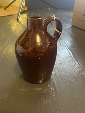 vintage brown ceramic or stoneware jug, likely used for storage of liquids such