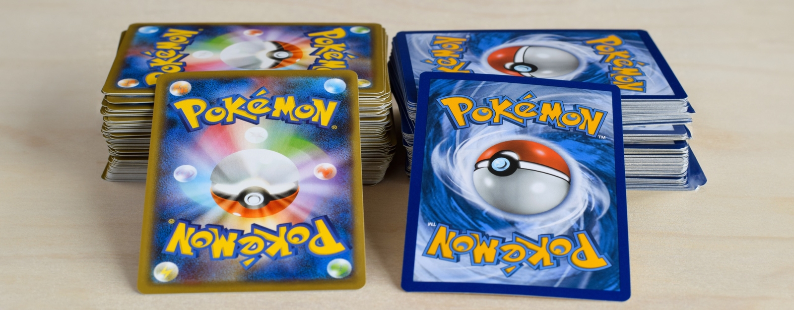 Aufnahme von zwei Stapeln an Pokémon Karten; einer mit japanischen und einer mit westlichen Karten.