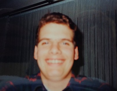 Junger Mann macht lachend ein Selfie von sich Farbfoto 