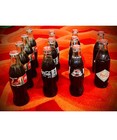 12 vintage Coca-Cola glass bottles (8oz each). All bottles are sealed and full. — photo 1
