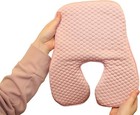 Hand holding a pink gel polymer and memory foam cushion with textured hexagonal pattern, resting on white background.