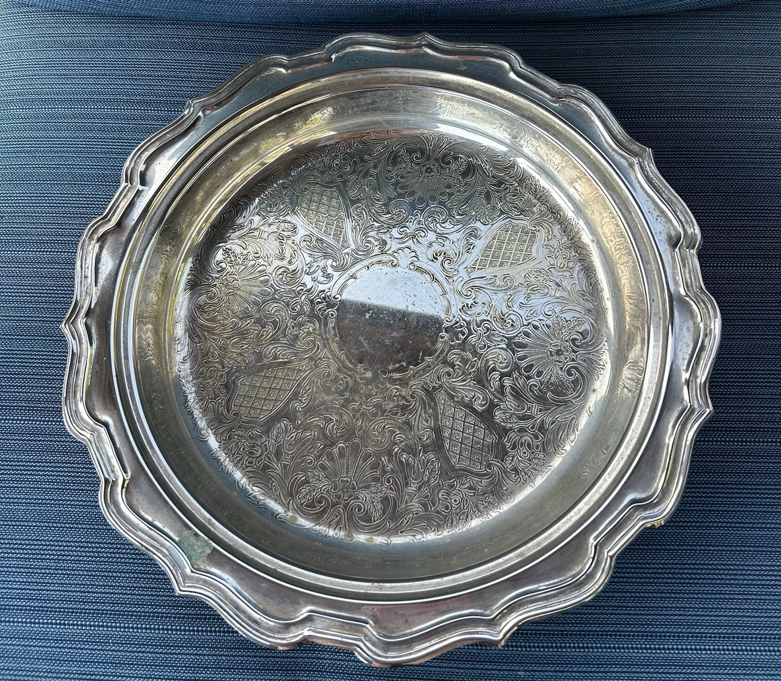 Round silverplate footed serving tray with ornate border, 13 inches