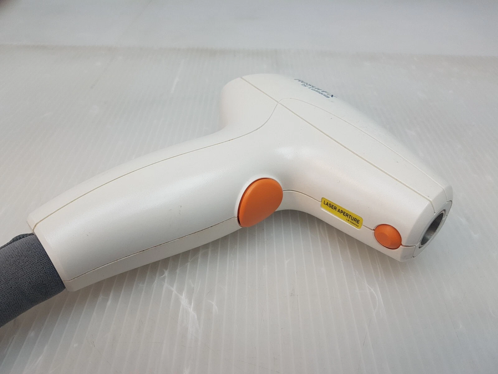 ResurFX handpiece side with orange trigger buttons and laser aperture label