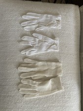 A collection of antique white and cream crocheted gloves.