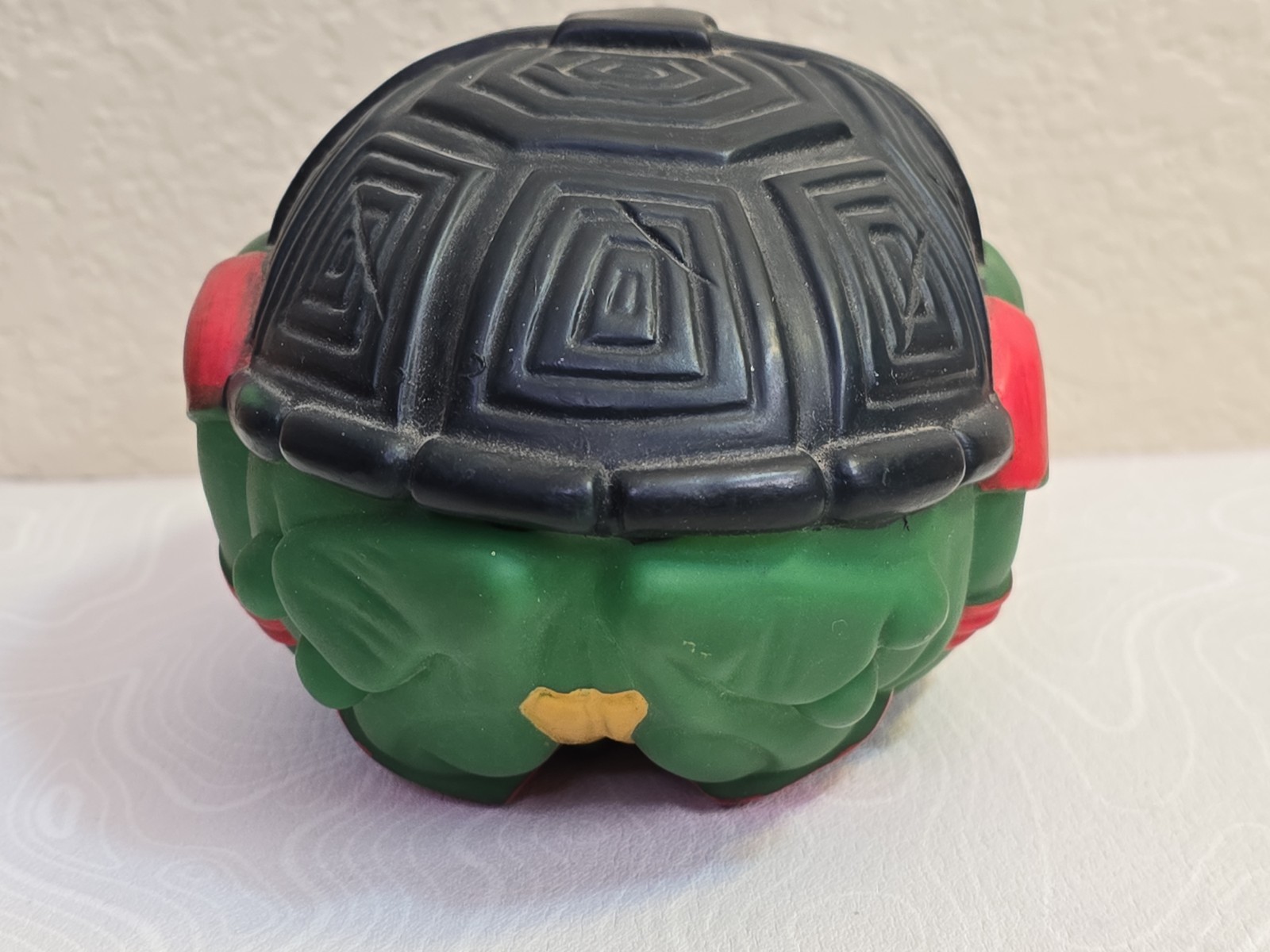 Black and green Teenage Mutant Ninja Turtles football Raphael with textured silver helmet and red tail.