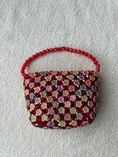 Czerwone koraliki i kolorowy pojemnik w kształcie torby na kwiaty