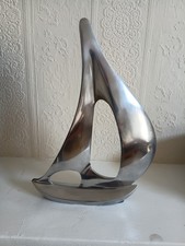 Silver-toned aluminum sailing boat sculpture.