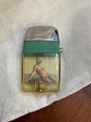 VINTAGE SCRIPTO VU-LIGHTER WITH GREEN BAND AND PIN UP OF A WOMAN ON THE BEACH