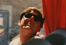 Man With Red Clown Nose Sunglasses Tour Bus Red Curtain Playful Pose Silly Guy