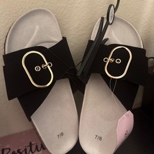 woman black sandals with gold buckle