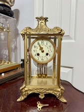 A FRENCH GILT-SPELTER AND BRASS FOUR-GLASS MANTELCLOCK