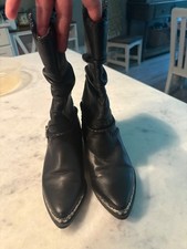 black Zodiac slouch western boots feature silver-toned metal hardware accents on