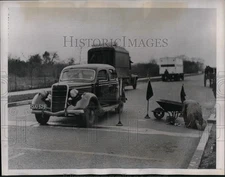 1937 Press Photo Workmen on his hand and knees take a Fingerprint of the Road.