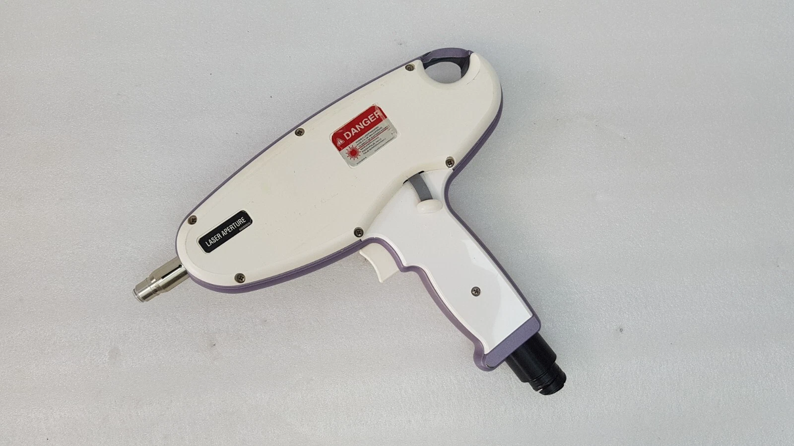Quantum handpiece side with red DANGER laser label, LASER APERTURE label and trigger