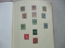 AN OLD STANLEY GIBBONS JUNIOR  STAMP ALBUM WITH A COLLECTION OF STAMPS